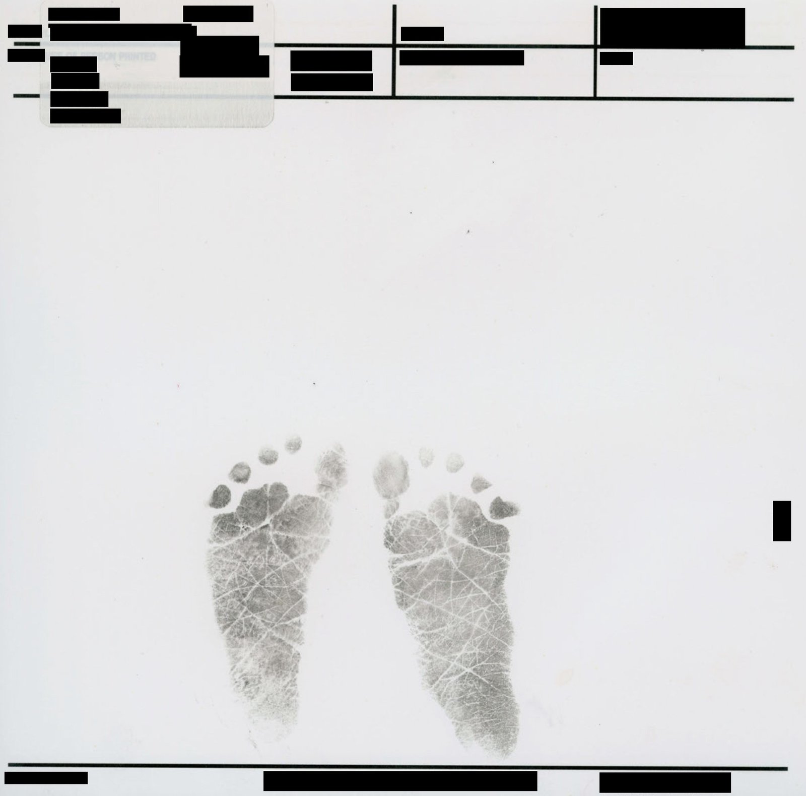A pair of black ink footprints from an infant centered on a white page. Above and below the footprints are several rows of official form fields and identifying information, all of which have been redacted with solid black bars.