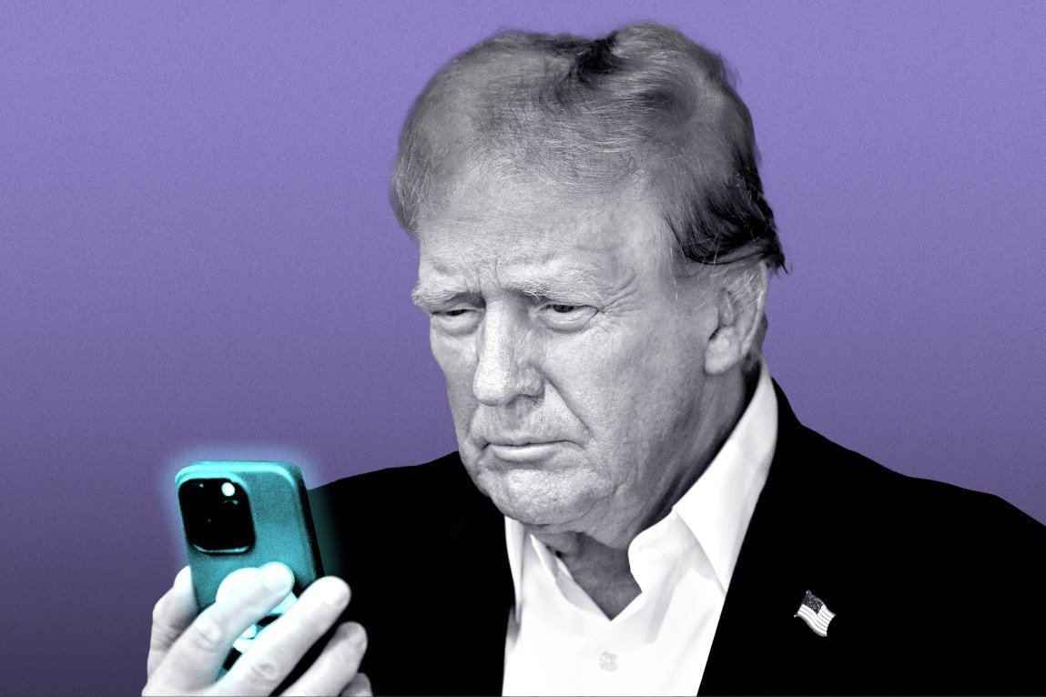 President Donald Trump looks at the glowing phone in his hand.