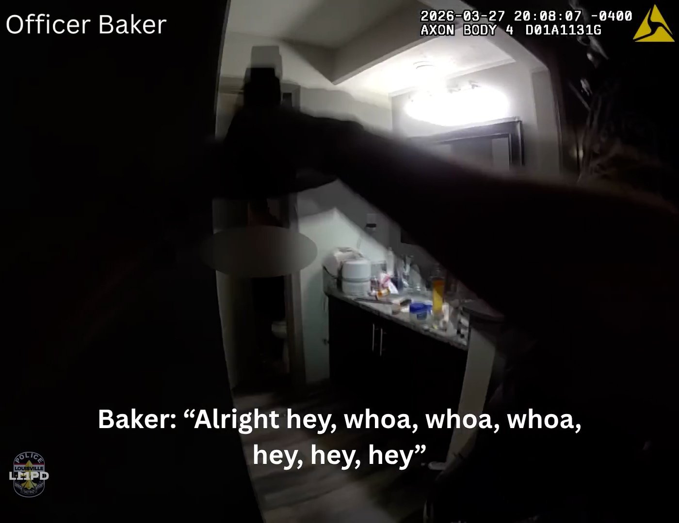 A body camera shows a police officer aiming a gun and flashlight into a bathroom as he looks at the doorway. The screen includes subtitles at the bottom reading,